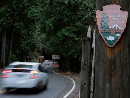 FILE - In this Jan. 28, 2019, file photo, a car drives past the Nisqually entrance to Mount Rainier National Park in Washington state. After closing amid the coronavirus pandemic, the National Park Service is testing public access at several parks across the nation, including two in Utah, with limited …