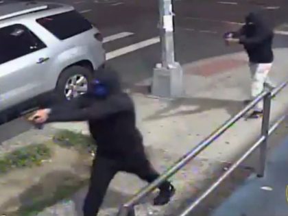 Two masked and hooded men walked up to a crowd near a laundromat and barbershop in the New York City borough of Queens and opened fire, wounding 10 people, including three known gang members, before escaping on mopeds, police said Sunday morning.