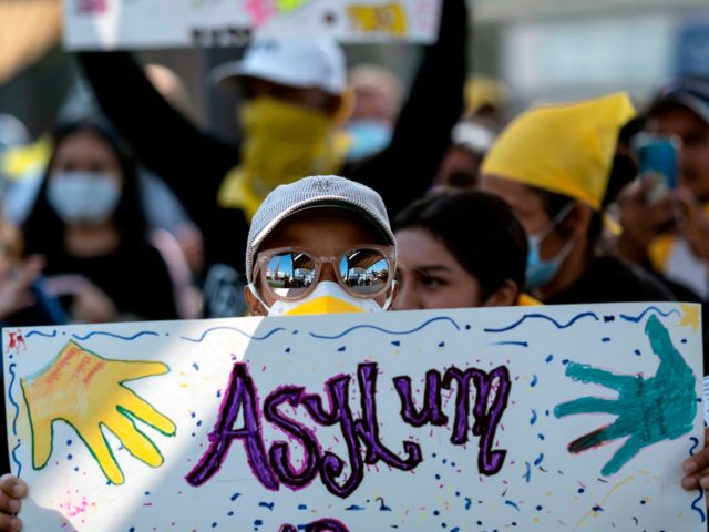 A migrant holds a sign during a protest against US and Mexican migration policies at the S