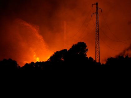 Fires rage through the countryside in Cuglieri, near Oristano, Sardinia, Italy, early Sunday, July 25, 2021. Hundreds of people were evacuated from their homes in many small towns in the province of Oristano, Sardinia, after raging fires burst in the areas of Montiferru and Bonarcado. (Alessandro Tocco/LaPresse via AP)
