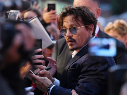 VENICE, ITALY - SEPTEMBER 06: Johnny Depp signs autographs on the red carpet ahead of the