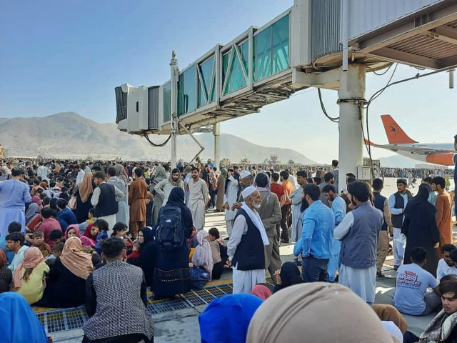 OPSHOT - Afghans crowd at the tarmac of the Kabul airport on August 16, 2021, to flee the country as the Taliban were in control of Afghanistan after President Ashraf Ghani fled the country and conceded the insurgents had won the 20-year war. (Photo by - / AFP) (Photo by …