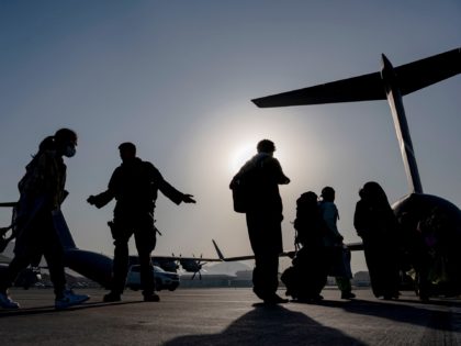 In this image provided by the U.S. Air Force, U.S. Air Force Airmen guides evacuees aboard a U.S. Air Force C-17 Globemaster III at Hamid Karzai International Airport in Kabul, Afghanistan, Tuesday, Aug. 24, 2021. (Senior Airman Taylor Crul/U.S. Air Force via AP)