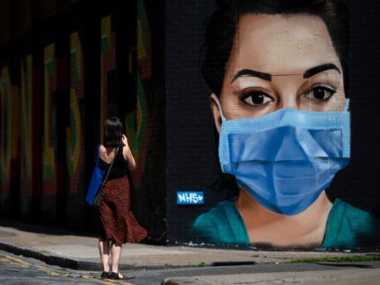 LONDON, UNITED KINGDOM - APRIL 23: A woman takes a photo of graffiti on Brick Lane in East London on April 23, 2020 in London, England. The British government has extended the lockdown restrictions first introduced on March 23 that are meant to slow the spread of COVID-19. (Photo by …