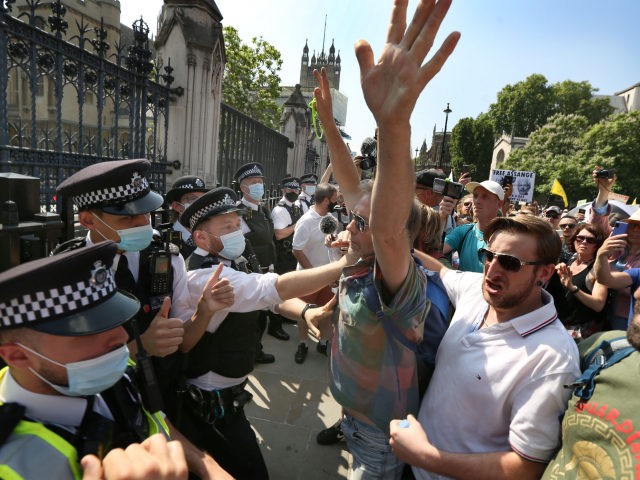 LONDON, ENGLAND - JULY 19: Protesters confront a police line outside the House of Commons during a freedom protest on July 19, 2021 in London, England. Anti-lockdown protests have been a feature of the Coronavirus Pandemic across the UK uniting the anarchist left and anti-establishment right. Many believe the popular …