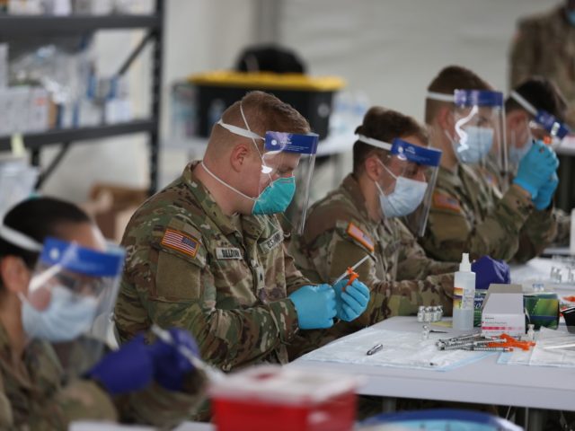 NORTH MIAMI, FLORIDA - MARCH 10: U.S. Army soldiers from the 2nd Armored Brigade Combat Team, 1st Infantry Division, prepare Pfizer COVID-19 vaccines to inoculate people at the Miami Dade College North Campus on March 10, 2021 in North Miami, Florida. The soldiers deployed to assist the Federal Emergency Management …
