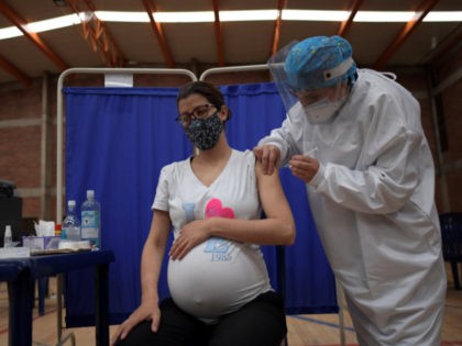 A pregnant woman receives a dose of the Pfizer-BioNTech vaccine against COVID-19 at a vaccination center in Bogota, on July 23, 2021. - Colombia started to inoculate pregnant women who have three months of gestation or more. (Photo by Raul ARBOLEDA / AFP) (Photo by RAUL ARBOLEDA/AFP via Getty Images)