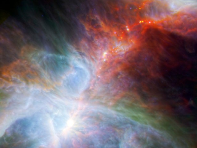 This image made available by NASA shows fledgling stars hidden in the gas and clouds of the Orion nebula, captured by infrared observations from the Spitzer Space Telescope and the European Space Agency's Herschel mission. In several hundred thousand years, some of the forming stars will accrete enough material to …