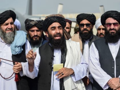 Taliban spokesman Zabihullah Mujahid (C) addresses a media conference at the airport in Kabul on August 31, 2021. - The Taliban joyously fired guns into the air and offered words of reconciliation on August 31, as they celebrated defeating the United States and returning to power after two decades of …