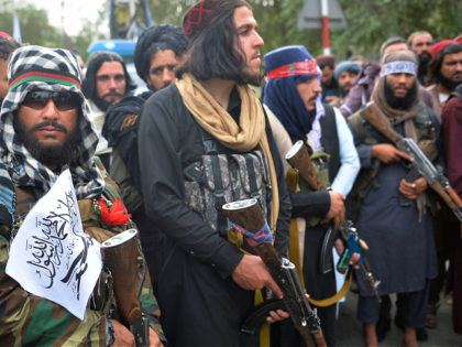 Taliban fighters gather along a street during a rally in Kabul on August 31, 2021 as they celebrate after the US pulled all its troops out of the country to end a brutal 20-year war -- one that started and ended with the hardline Islamist in power. (Photo by Hoshang …