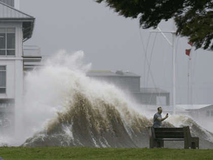 A man takes pictures of high waves along the shore of Lake Pontchartrain as Hurricane Ida nears, Sunday, Aug. 29, 2021, in New Orleans. (AP Photo/Gerald Herbert)