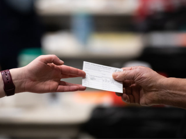 A patient receives a card showing when they received their first dose of the Pfizer Covid-19 vaccine at the Amazon Meeting Center in downtown Seattle, Washington on January 24, 2021. - Amazon is partnering with Virginia Mason for a one-day pop-up clinic on January 24. 2021 that aims to vaccinate …