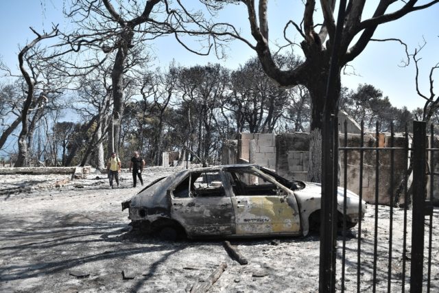 A car destroyed by flames east of Patras in the Peloponnese as Greece battles fires durin