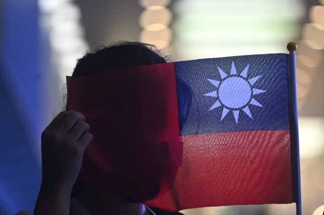 A woman holds a Taiwanese flag to mark the island's National Day. Beijing claims Taiwan as