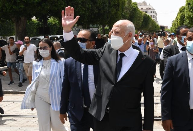Tunisian President Kais Saied, who has suspended parliament, waves as he walks with securi
