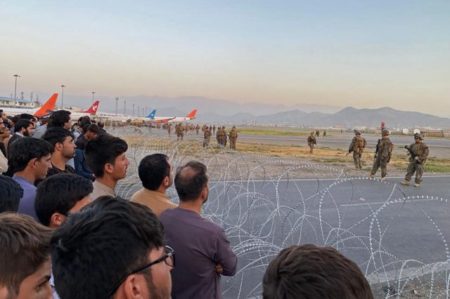 Afghans crowd Kabul airport as US soldiers stand guard while evacuations operations are un