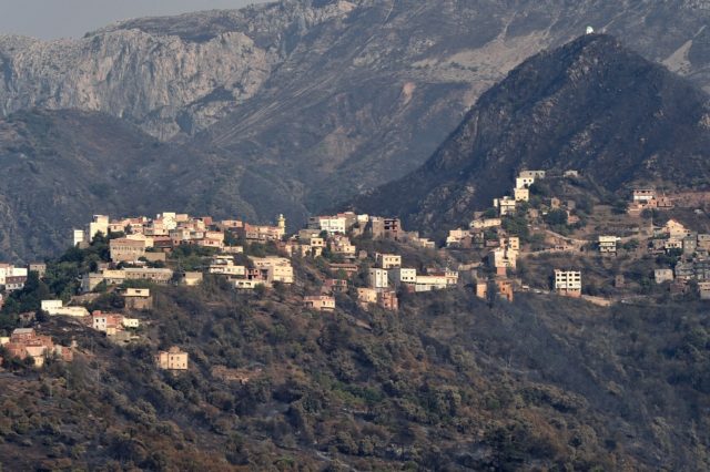 Burnt woodland surrounds an Algerian town, after days of intense fires were put out on Wed