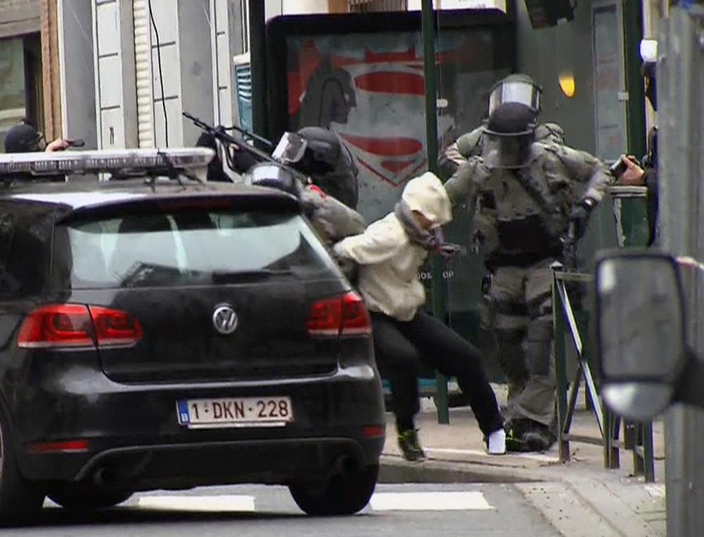 FILE - In this Friday March 18, 2016 file framegrab taken from VTM, Salah Abdeslam, centre, is arrested by police and bundled into a police vehicle during a raid in the Molenbeek neighborhood of Brussels, Belgium. Belgian prosecutors confirmed Wednesday April 27, 2016 that Paris attacks suspect Salah Abdeslam was handed over to French authorities. (VTM via AP) BELGIUM OUT