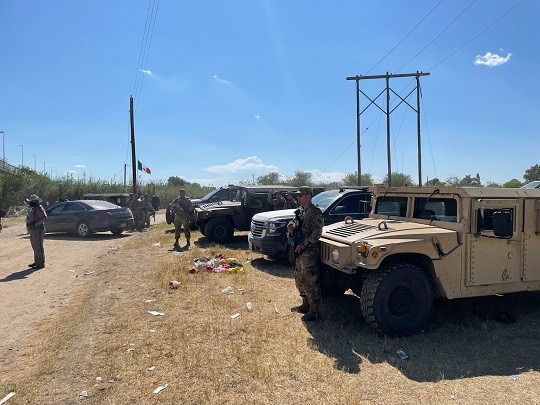 Texas DPS troopers and National Guard soldiers stand watch at the migrant camp under the Del Rio International Bridge. (Photo: Office of the Texas Governor)