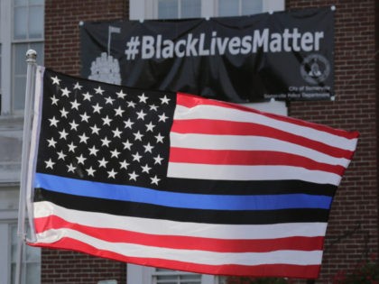 FILE - In this July 28, 2016, file photo, a flag with a blue and black stripes in support of law enforcement officers, flies at a protest by police and their supporters outside Somerville City Hall in Somerville, Mass. San Francisco's police chief said the city's rank and file will …
