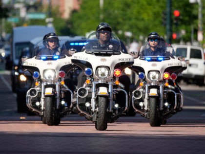 Denver Police Department motorcycle officers escort an armored vehicle carrying the most-sought after baseball card in the world, a PSA gem mint 10 1952 Topps Mickey Mantle card known as the Holy Grail of cards, to be put on display in the Hall of Legends at the Rally Hotel as …