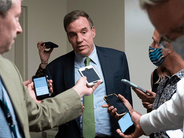 Sen. Mark Warner, D-Va., talks to reporters as he walks to the senate chamber ahead of a test vote scheduled by Democratic Leader Chuck Schumer of New York on the bipartisan infrastructure deal senators brokered with President Joe Biden, on Capitol Hill, in Washington, Wednesday, July 21, 2021. Republicans prepared to block the vote by mounting a filibuster over what they see as a rushed and misguided process. (AP Photo/Jose Luis Magana)