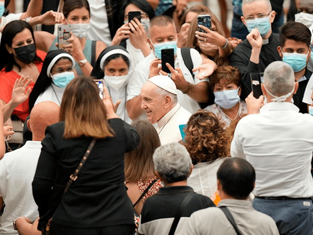 Pope Francis, center, is greeted by faithful during his weekly general audience, held in t