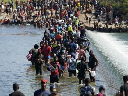 Haitian migrants use a dam to cross to and from the United States from Mexico, Friday, Sept. 17, 2021, in Del Rio, Texas. Thousands of Haitian migrants have assembled under and around a bridge in Del Rio presenting the Biden administration with a fresh and immediate challenge as it tries …