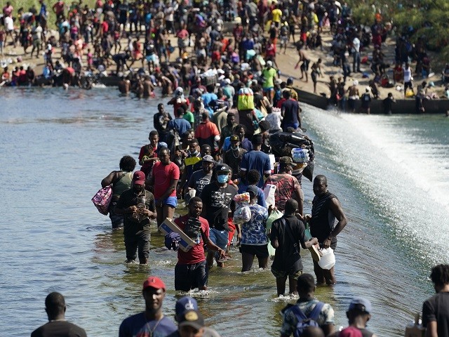 Haitian migrants use a dam to cross to and from the United States from Mexico, Friday, Sept. 17, 2021, in Del Rio, Texas. Thousands of Haitian migrants have assembled under and around a bridge in Del Rio presenting the Biden administration with a fresh and immediate challenge as it tries to manage large numbers of asylum-seekers who have been reaching U.S. soil. (AP Photo/Eric Gay)