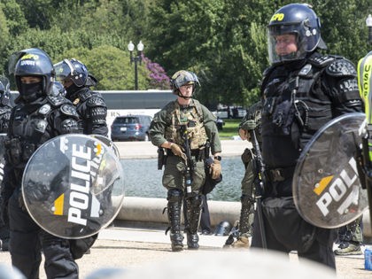 Washington DC - September 18: Members of the Arlington County, VA police department support the US Capitol Police while in full riot gear stand near the site where the Justice for J6 rally takes place in Washington DC. The rally is held to support those who were charged with criminal …