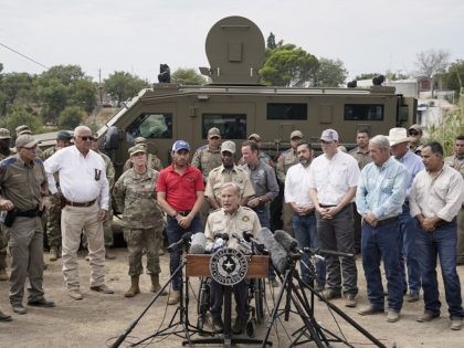 Texas Gov. Greg Abbott, center, speaks during a news conference along the Rio Grande, Tuesday, Sept. 21, 2021, in Del Rio, Texas. The U.S. is flying Haitians camped in a Texas border town back to their homeland and blocking others from crossing the border from Mexico. (AP Photo/Julio Cortez)