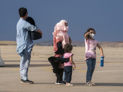 An Afghan family wait on the runway after disembarking a plane from Afghanistan, at the Torrejon military base as part of the evacuation process in Madrid, Monday. Aug. 23, 2021. (AP Photo/Andrea Comas)