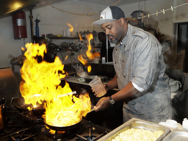 HOLD FOR STORY BY COREY WILLIAMS- In a photo from Friday, Nov. 17, 2017, in Detroit, River Bistro chef Maxcel Hardy prepares a Caribbean shrimp dish at his restaurant. The city allows chefs and prospective restaurant owners to realize their dreams at a lower financial cost than other places, like New York, according to chef Hardy. “If you had a passion and a dream to open a restaurant, Detroit is one of those areas where you can do it and at a decent price,” said Hardy. (AP Photo/Carlos Osorio)
