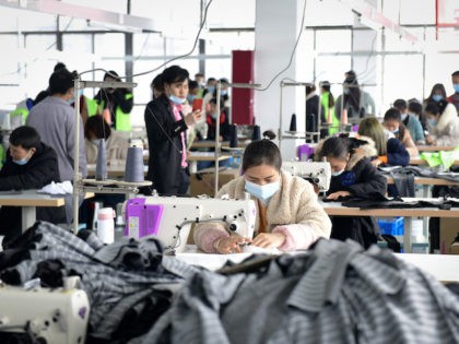 This photo taken on February 22, 2021 shows employees making clothes at a factory of a clothing company in Anlong county, in China's southwestern Guizhou province. (STR/AFP via Getty Images)