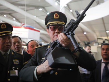 Chinese officers check on rifles of ARES Defense Systems, Inc from the U.S. during the opening of the 9th Sprcial Operations Forces Exhibition and Conference (Sofex), in Amman, Jordan on May 08, 2012. (Photo by Salah Malkawi/ Getty Images)