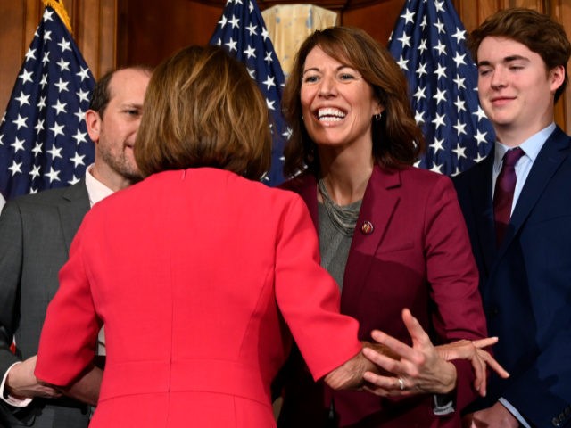 House Speaker Nancy Pelosi of Calif., left, gives a hug to Rep. Cindy Axne, D-Iowa, poses