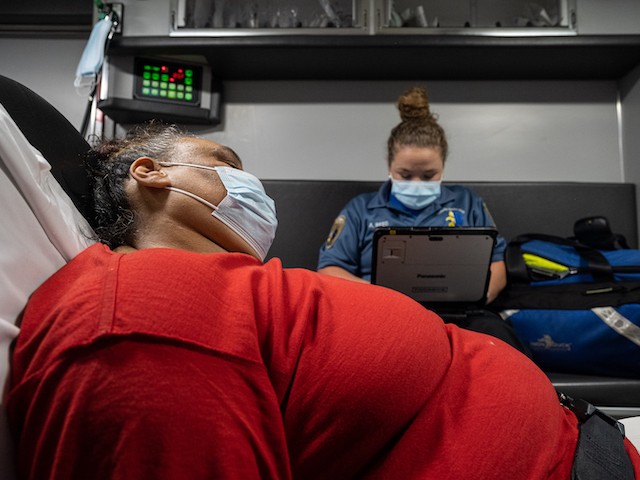 A patient experiencing a coronavirus emergency speaks with a member of Louisville Metro Emergency Medical Services in an ambulance outside of the patient's home on September 13, 2021 in Louisville, Kentucky. (Jon Cherry/Getty Images)