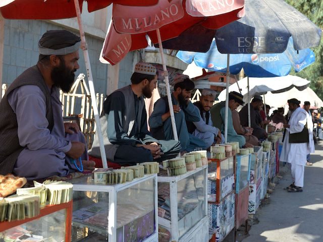 Money changers sit at the currency exchange market along a road in Kandahar on September 20, 2021. (Javed Tanveer/AFP via Getty Images)