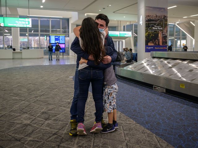 Samuel, his wife Dania and his son Daniel from Honduras embrace at LaGuardia airport in New York on March 30, 2021 after being separated for months. Dania and Daniel were released from a US government holding facility for illegal migrants seeking asylum in McAllen, Texas. (Ed Jones/AFP via Getty Images)