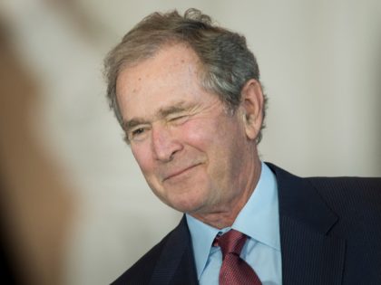 Former US President George W. Bush winks on December 3, 2015, during a dedication ceremony hosted by the US Senate at Emancipation Hall of the US Capitol Visitor Center in Washington, DC. The ceremony unveiled a bust of former US Vice President Dick Cheney, who as vice president, also served …