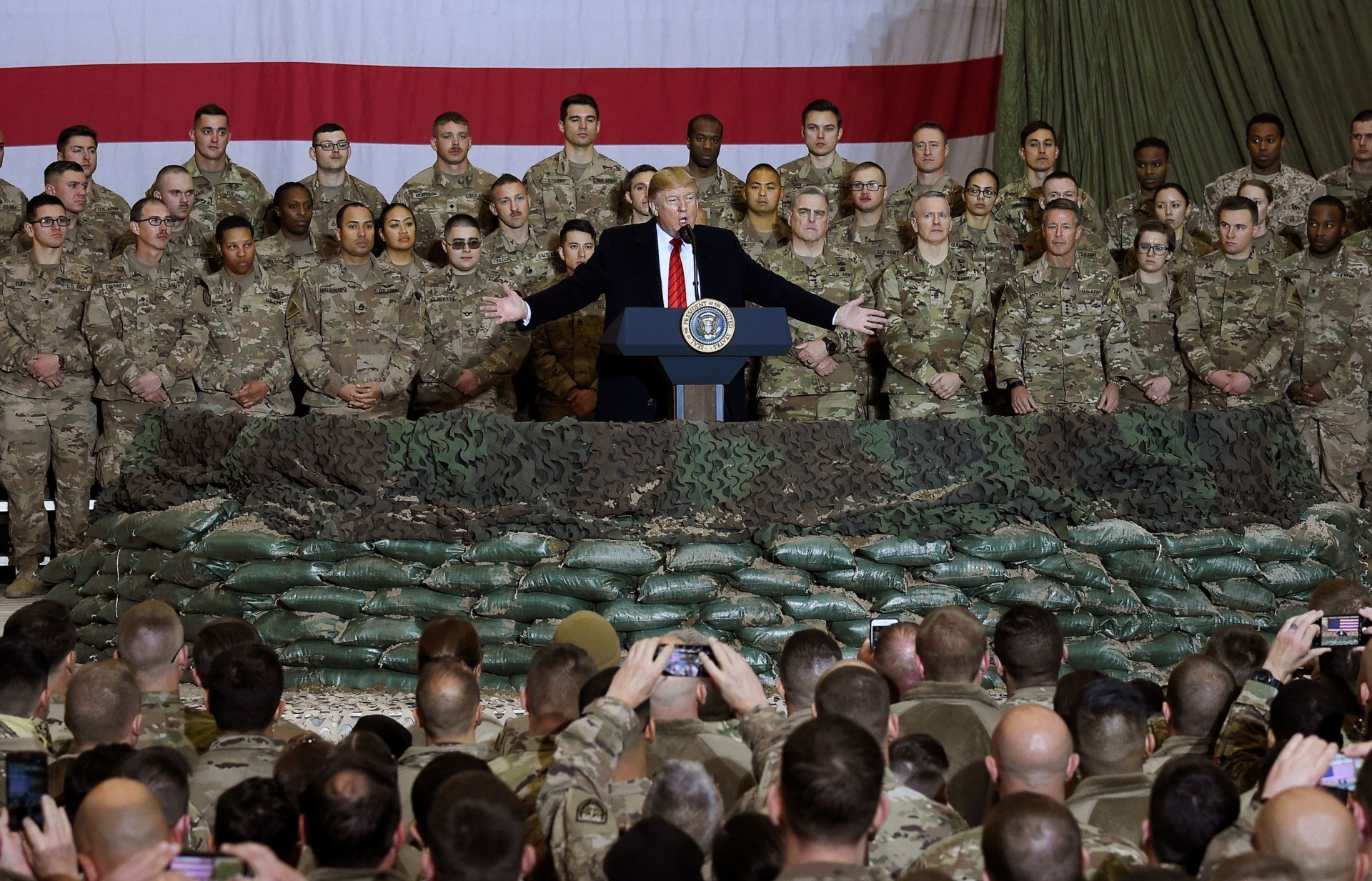 (FILES) In this file photo taken on November 28, 2019, US President Donald Trump speaks to the troops during a surprise Thanksgiving day visit at Bagram Air Field in Afghanistan. - President Donald Trump has shattered through norms and niceties on the world stage in his nearly three years in office. Entering an election year, Trump is unlikely to slow down as he seeks what has largely eluded him -- a headline-grabbing victory. The tycoon turned president closes 2019 with a new stride after what was perhaps his most unambiguous achievement -- US commandos' raid that killed the leader of the Islamic State extremist group. But the year was also full of tosses and turns for Trump. On his ambition to end the war in Afghanistan, he startled Washington by inviting the Taliban to talks but then declared the talks dead before resuming them. (Photo by Olivier Douliery / AFP) (Photo by OLIVIER DOULIERY/AFP via Getty Images)