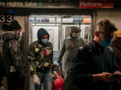 NEW YORK, NY - APRIL 17: Commuters wear face masks as they exit a subway train on April 17, 2020 in New York City. Following a new order from Governor Andrew Cuomo that New Yorkers must wear face coverings whenever social distancing is not possible, the measure is the latest …