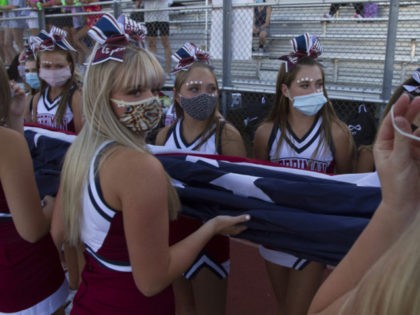 HERRIMAN, UT - AUGUST 13: Cheerleaders of the Herriman Mustangs carry the American Flag at Mustang Stadium on August 13, 2020 in Herriman, Utah. The Mustangs faced the Davis Darts in the first high school football game in the country this season since the spread of the coronavirus (COVID-19). (Photo …