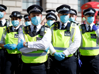 Police officers wearing face masks and gloves due to the COVID-19 pandemic, stand on duty as activists from the climate protest group Extinction Rebellion demonstrate in Parliament Square in London on September 2, 2020, on the second day of their new season of "mass rebellions". - Climate protest group Extinction …
