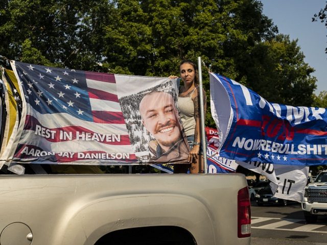 SALEM, OR - SEPTEMBER 07: Rebecca Thomas, a participant in a pro-Trump caravan rally, poses with a flag in memory of Aaron Jay Danielson, on September 7, 2020 in Salem, Oregon. Danielson was killed during another, recent pro-Trump caravan rally. Todays event, billed as the Oregon For Trump 2020 Labor …