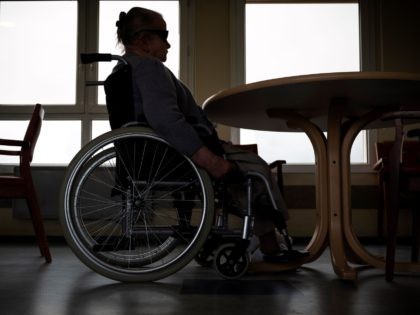 A resident sits in a wheelchair in a common room Les Cazelles retirement home in Bozouls,