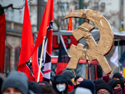 Left wing protesters display a golden hammer and sickle symbol during a yearly demonstration held by various leftist parties and organisations to commemorate the assassination of Communist icons Rosa Luxemburg and Karl Liebknecht in 1919, in Berlin on January 10, 2021. - Scores of demonstrators were detained for displaying symbols …