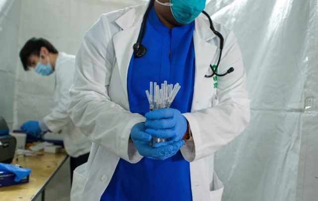 A health worker carries syringes to administer Pfizer Covid-19 vaccines at the opening of
