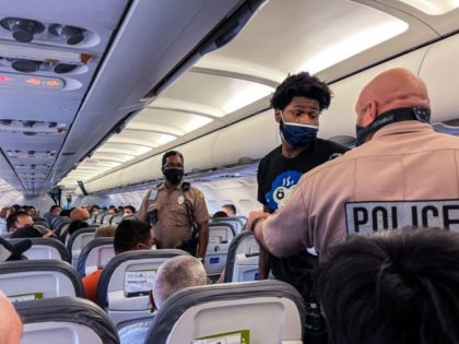 An officer from the Airport District Police of Miami International Airport removes passenger Dontavious Jackson (2nd R) from a United Airlines flight in Miami, on March 17, 2021, after Jackson was accused of wrongdoing by another passenger. - Jackson was later let go based on various eye witness statements from …
