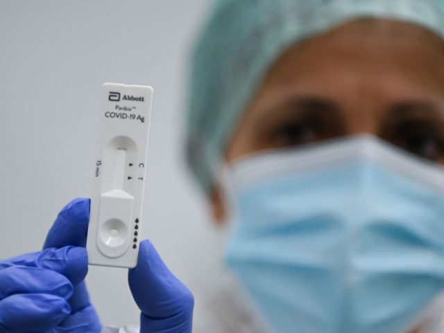 A medical worker shows a Covid-19 rapid antigen test, in the test area at Malpensa Airport in Milan on 3 April 2021, as passengers are being tested after disembarking from the first "Covid-tested" and "quarantine-free" flight from New York to northern Italy. (Photo by Piero Cruciatti / AFP) (Photo by …